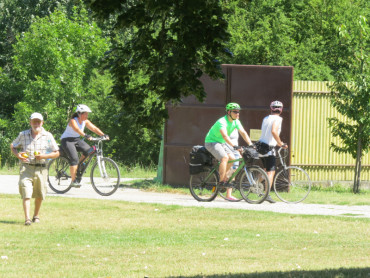 Pri bráne vchádzajú cykloturisti.