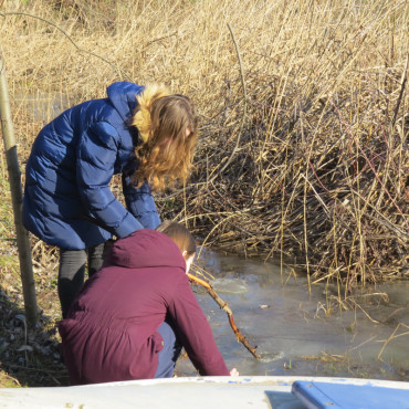 Dve študentky pri jazere sa chystajú na odobranie vzorky vody.
