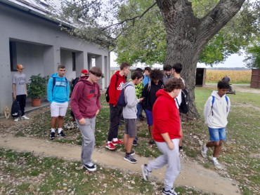 Tanulók gyülekeznek az épület előtt.