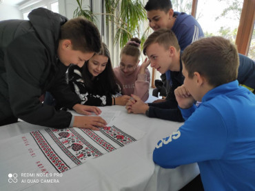 Pupils at the table solve the task of the game Island.